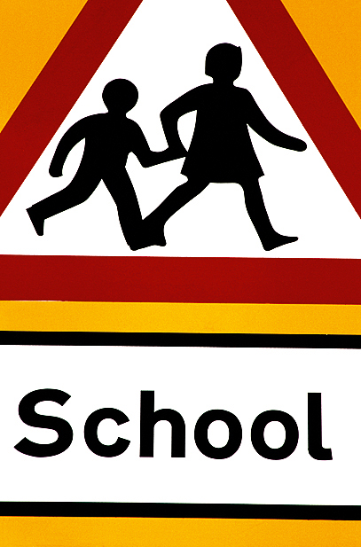 A road sign in front of school